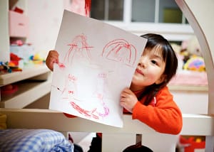 girl holding paper with drawing