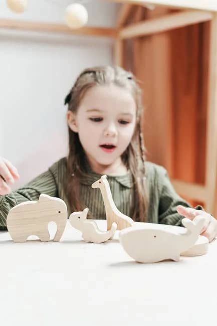 A young girl enjoys playtime with wooden animal toys in a cozy indoor setting.