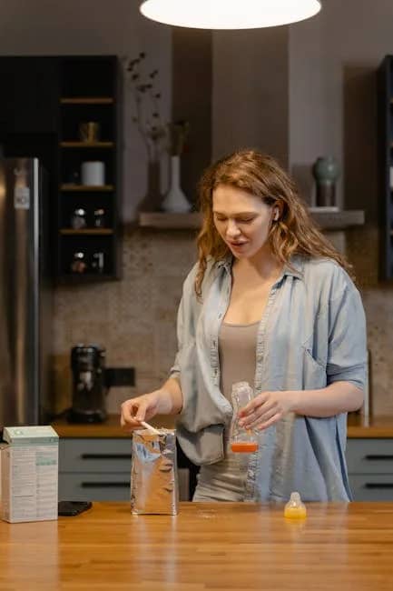 A mother prepares baby formula in a warm, cozy kitchen setting with soft lighting.