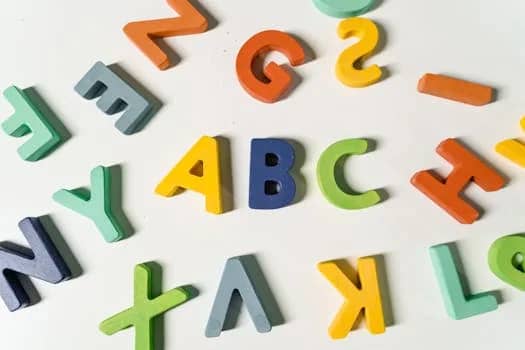 Bright, colorful wooden alphabet letters scattered on a surface ideal for children's learning.