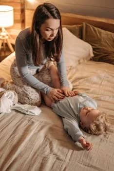 Mother and child bonding in a warm, cozy bedroom setting.